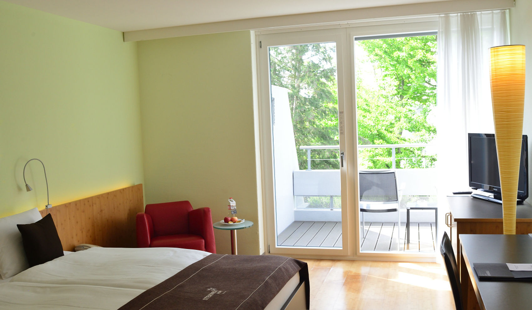 Hotelzimmer mit Balkon und Grünblick