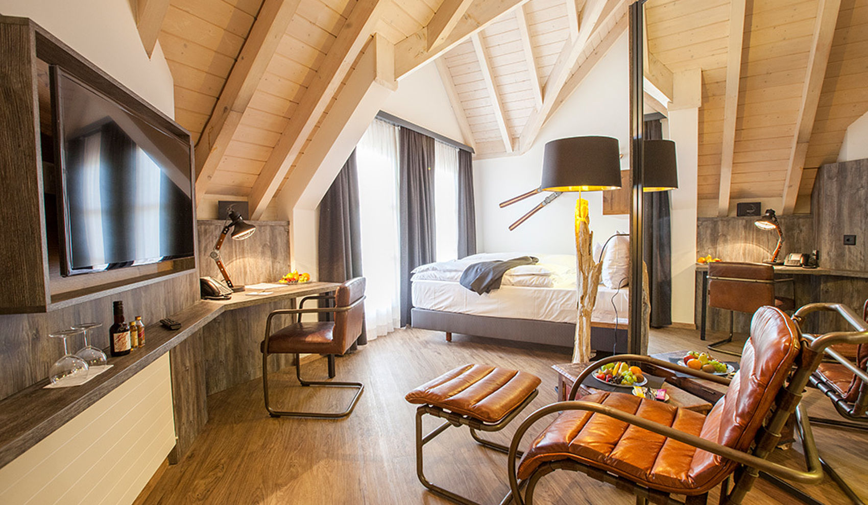 Boutique-Zimmer mit Holzbalken und Ledersessel