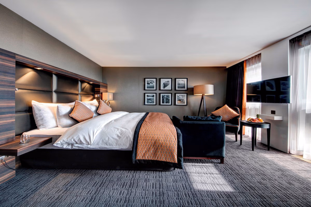 Hotelzimmer mit bodentiefem Fenster und Blick auf den Neuenburgersee