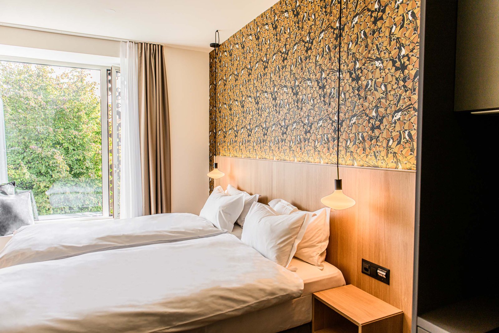 Hotelzimmer mit Designtapete und Holzelementen